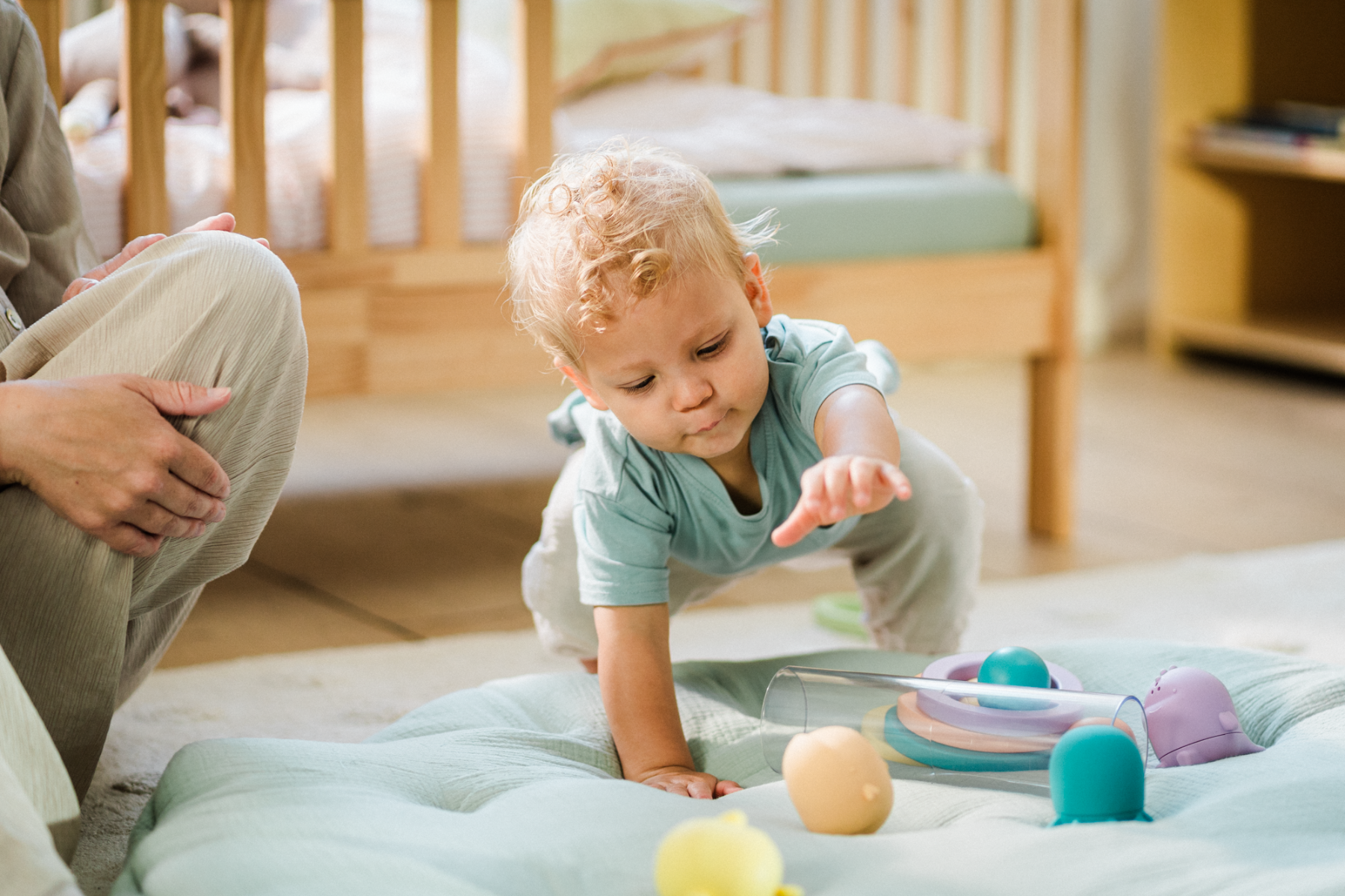 Bébé attrapant des objets colorés, développant la motricité globale et la coordination main-œil