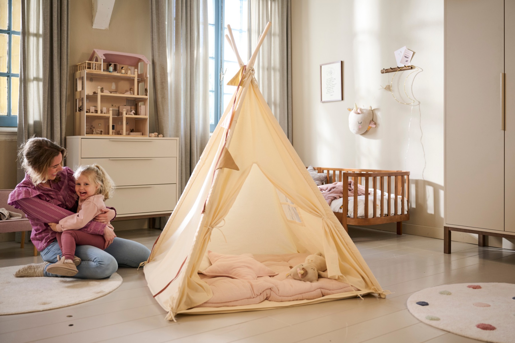 Maman avec sa fille jouant autour d'un tipi