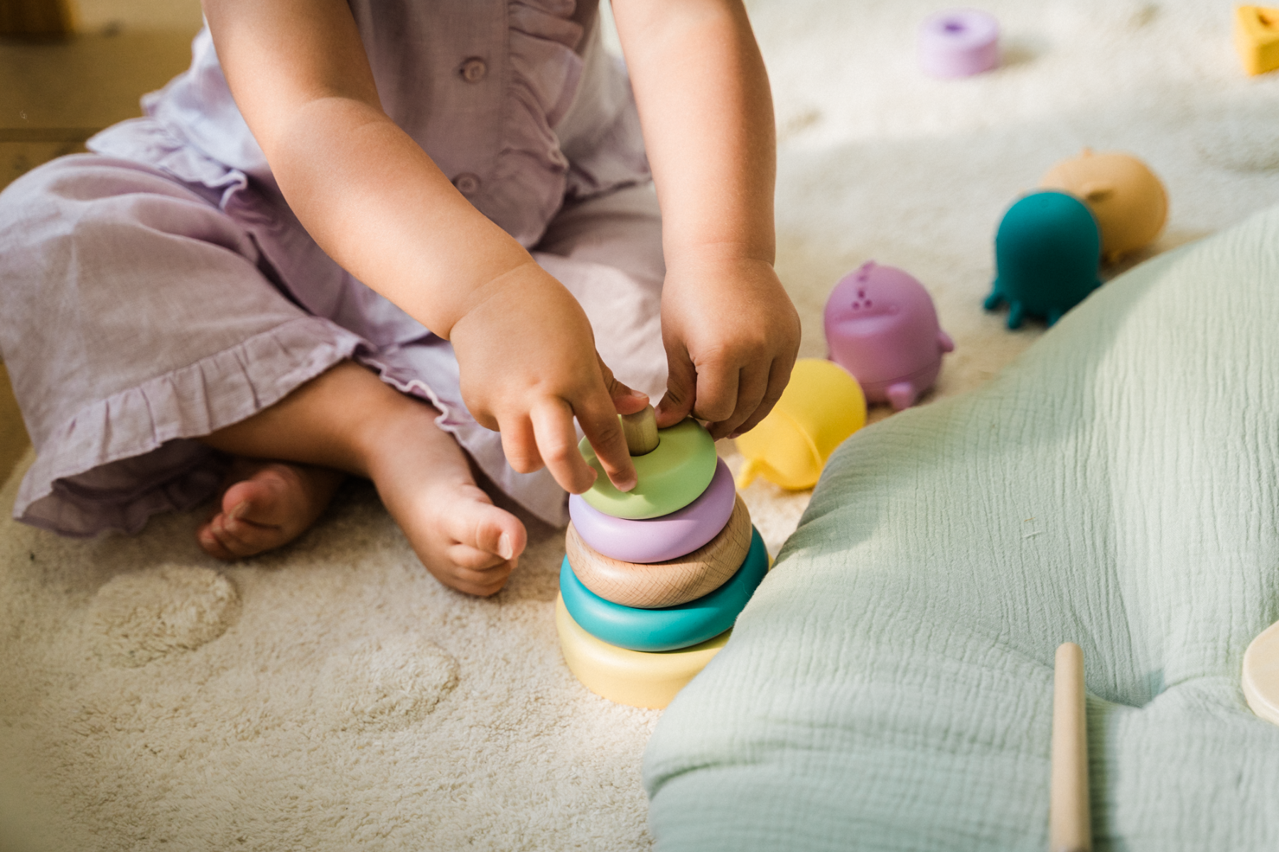 Enfant empilant des anneaux colorés, développant la motricité fine et la coordination main-œil