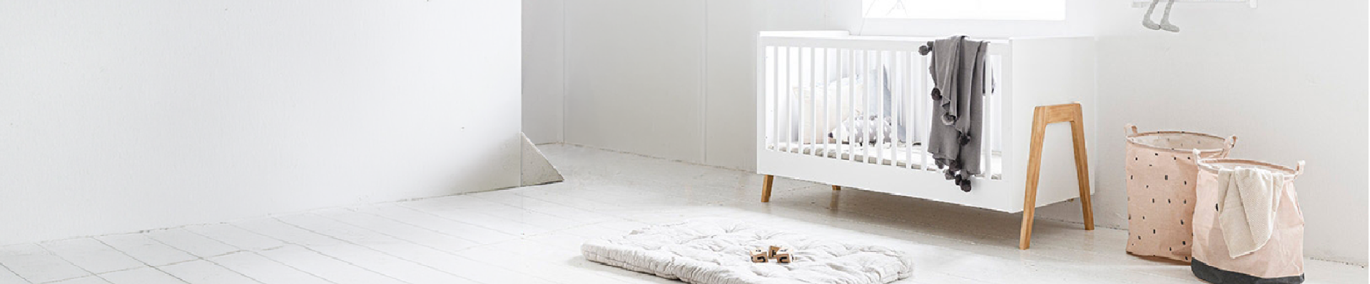 Chambre bébé avec lit blanc et tapis de jeu